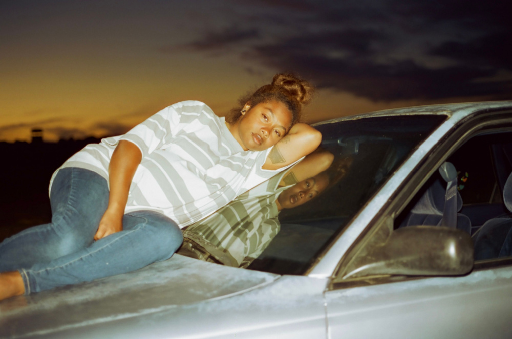 Earth Mama - Tia Nomore laying on hood of car