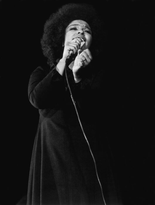 Roberta Flack singing during a live performance, highlighting the legendary vocalist featured in OWN’s documentary “OWN Spotlight: Roberta.”