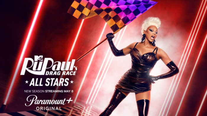 “RuPaul promotes RuPaul’s Drag Race All Stars Season 11, streaming May 8 on Paramount+, wearing a black latex dress and holding a checkered flag”