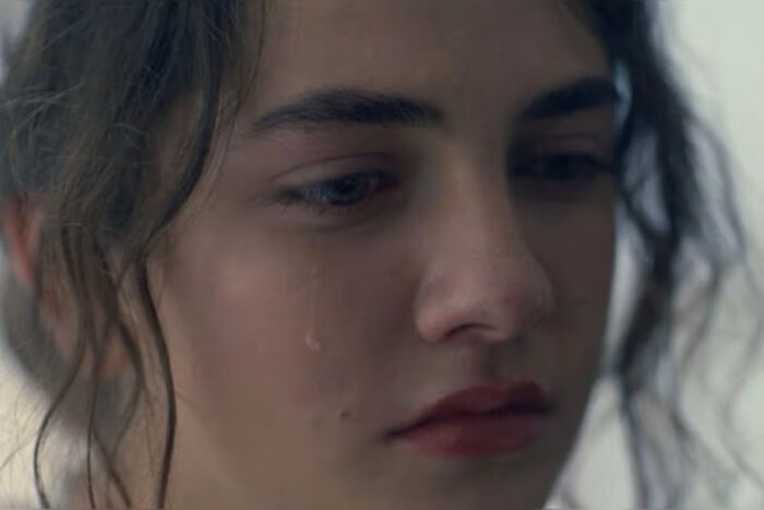 Becka sits in a prison cell in “The Testaments” finale while singing “Rise, Shine, and Give God the Glory.”