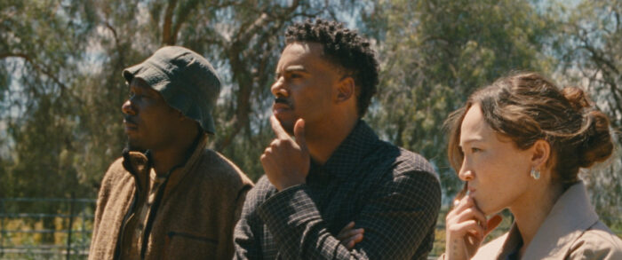 Théodore Pellerin, Archie Madekwe, and Havanna Rose Liu in Lurker (2026) on HBO Max standing outdoors in a tense, contemplative moment