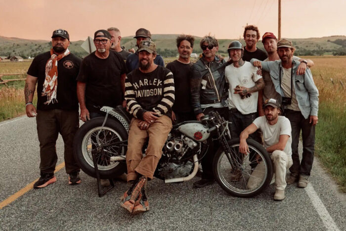 Jason Momoa with crew members and custom motorcycle in On The Roam Season 2 on HBO Max during a roadside moment in a rural setting