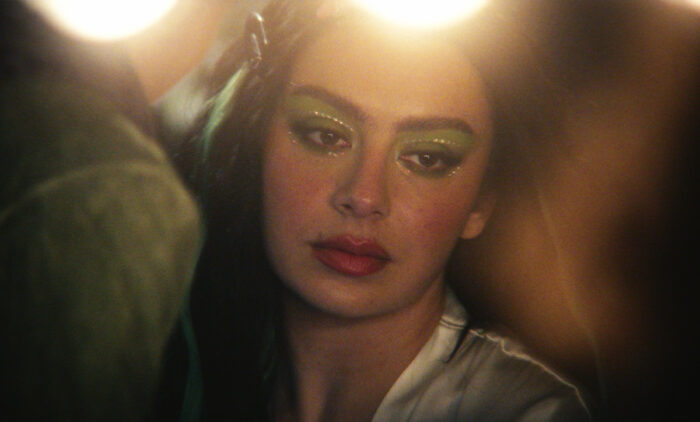 Charli XCX in The Moment (2026) A24 film wearing glitter eye makeup in a soft, cinematic close-up scene
