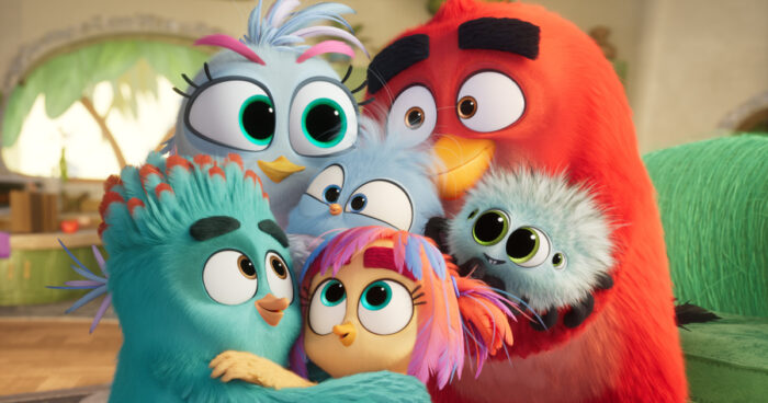 Silver and Red embrace their children Glider, June, and Olly alongside their pet Fuzzy in a family scene from "The Angry Birds Movie 3."